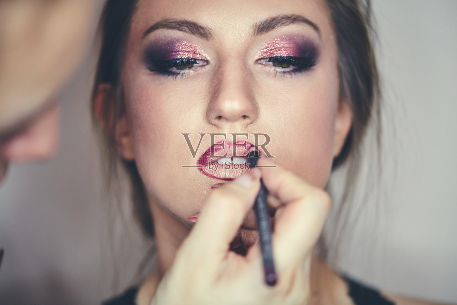 年轻漂亮的女人正在化妆。化妆的过程。照片摄影图片