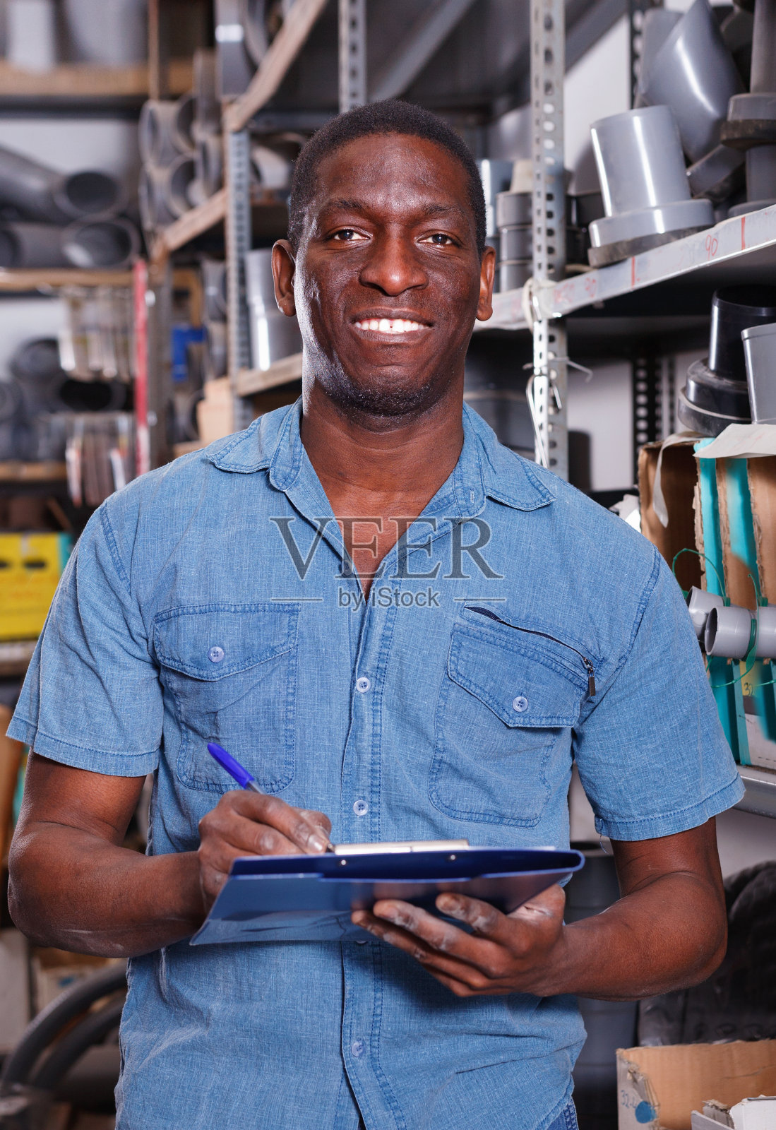 非裔美国人售货员在建材商店货架上检查商品的供应情况照片摄影图片