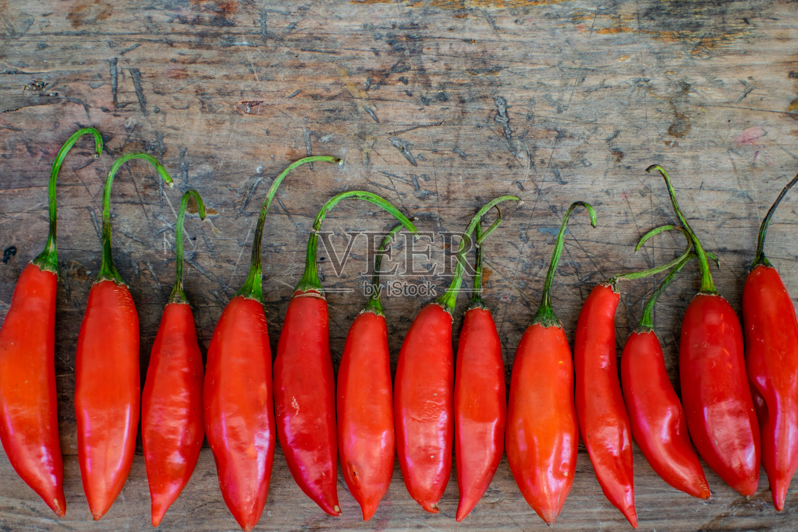 “红辣椒在质朴的木头背景上，带有书写区域。”照片摄影图片