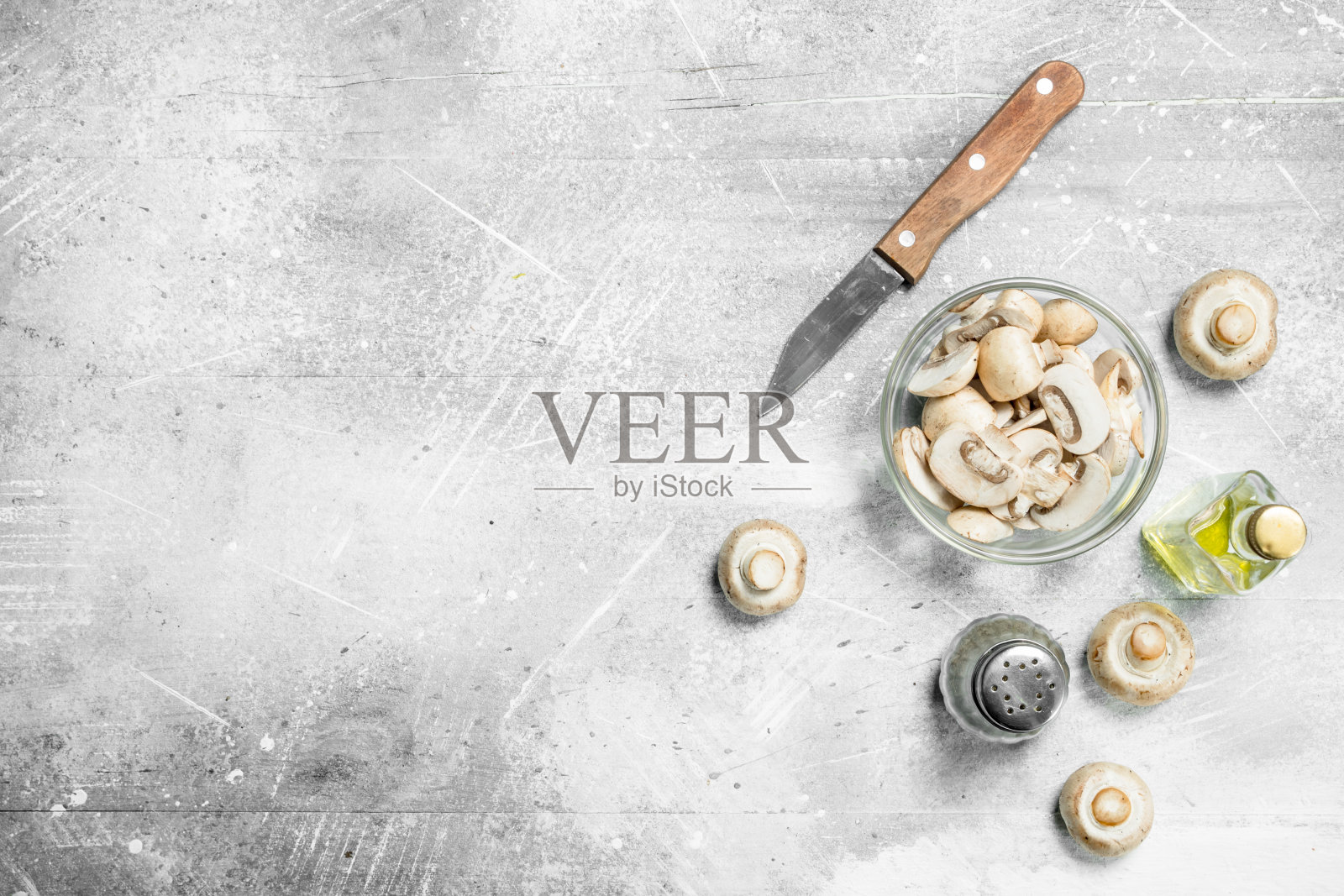 蘑菇切片放入碗中，用油、胡椒、刀切成薄片。照片摄影图片