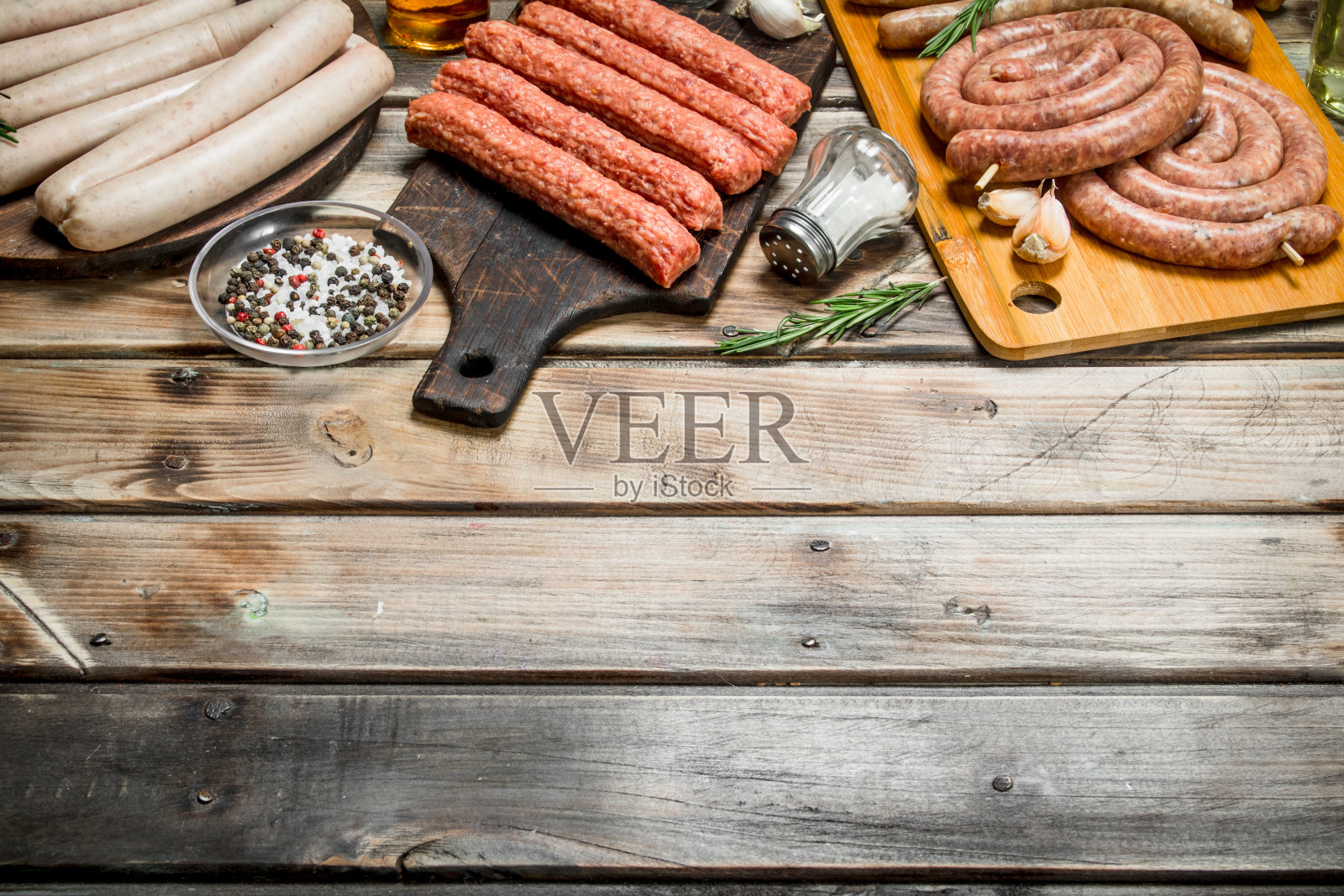 不同种类的生香肠加上调味料和香草。照片摄影图片