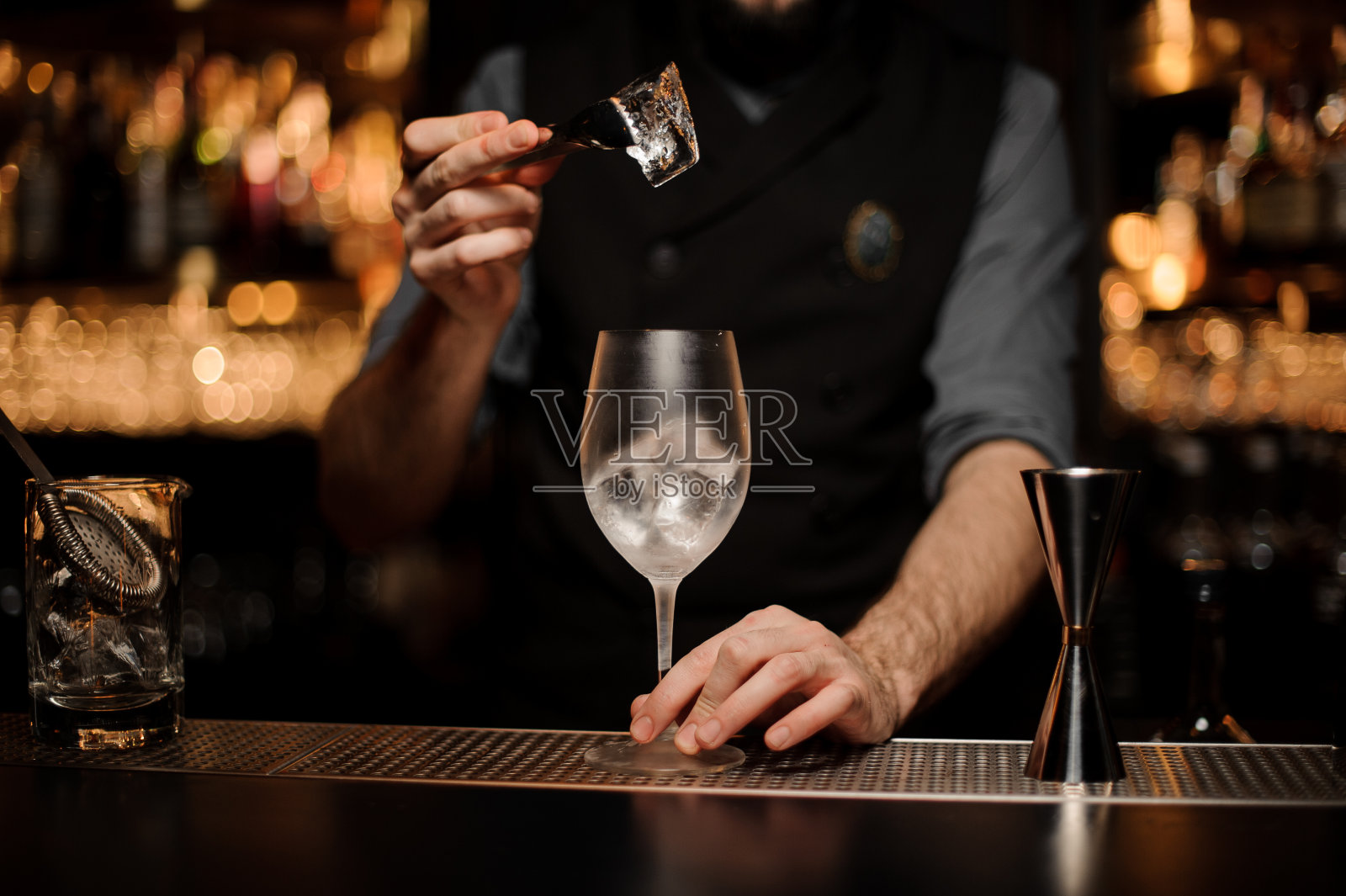 有胡子的酒保在玻璃杯里放冰照片摄影图片