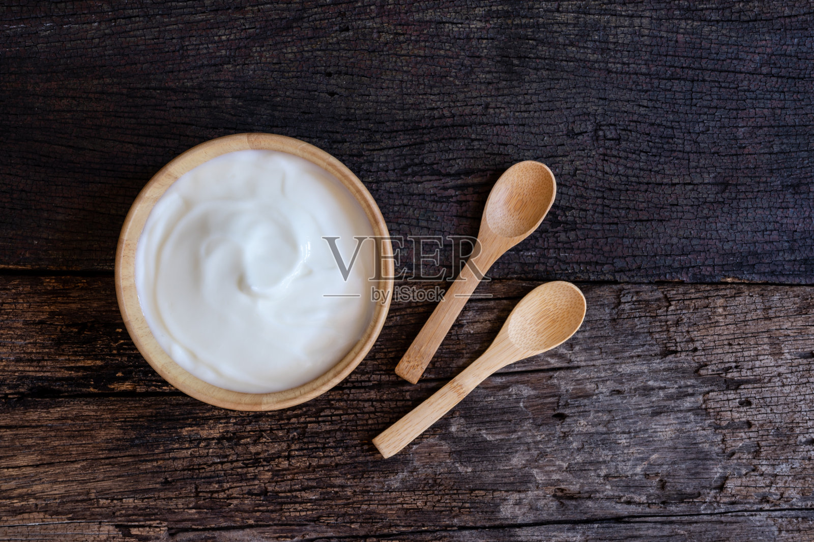 天然自制原味有机酸奶在木碗上，以木纹为背景，复制空间照片摄影图片