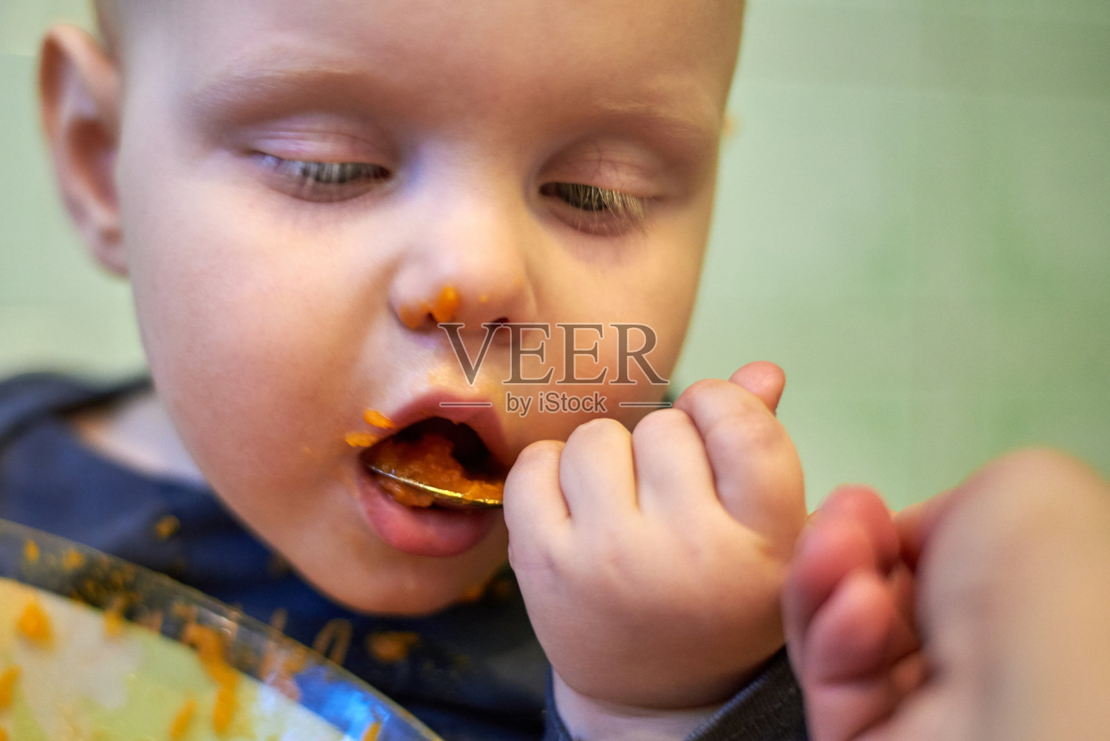 小婴儿学会用勺子自己吃饭照片摄影图片