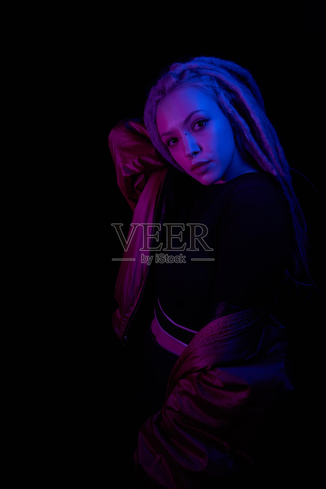 美丽的女孩在霓虹灯灯光下浅蓝色紫色的黑色背景照片摄影图片
