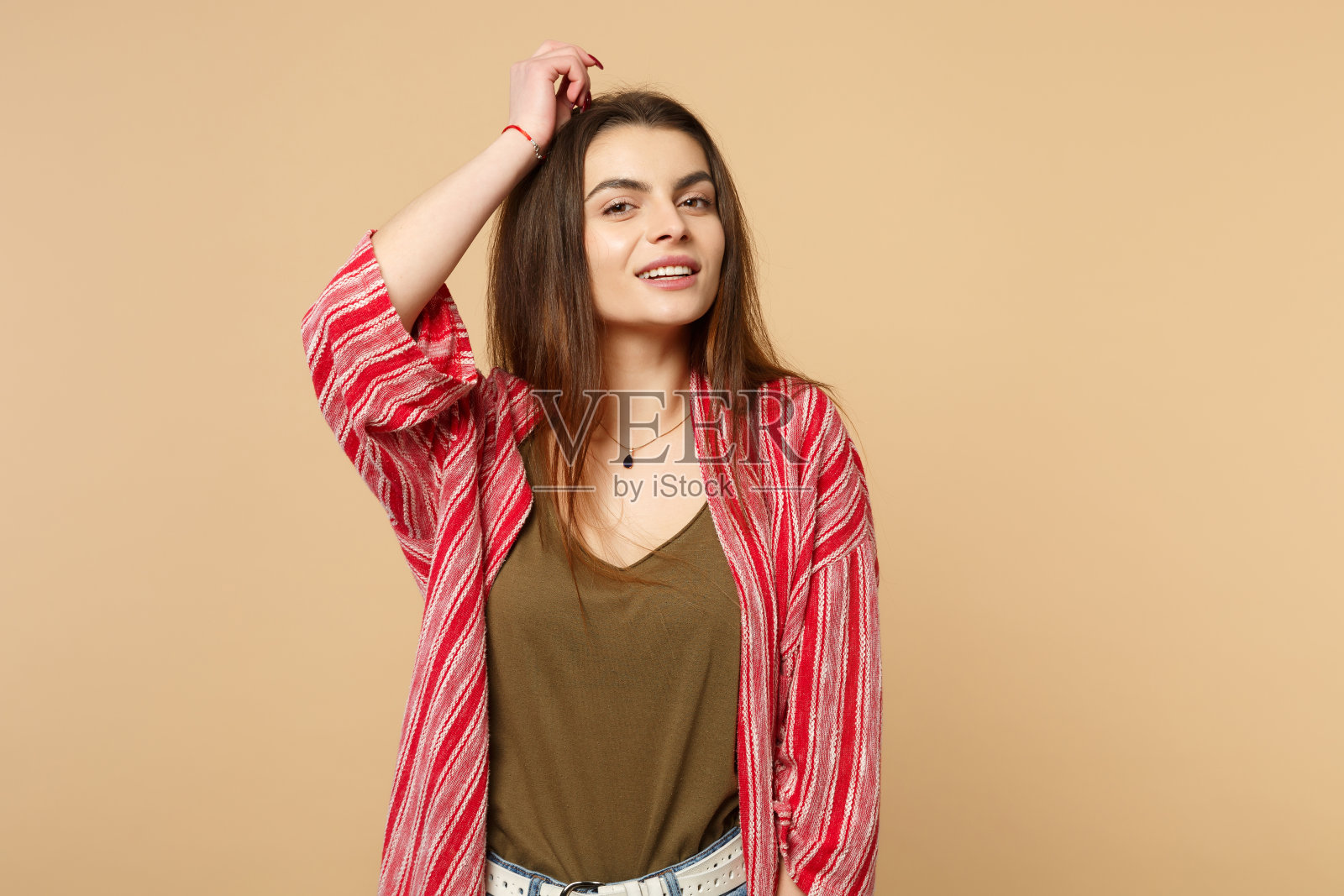 温柔的年轻女人的肖像在休闲衣服看相机和上升的手孤立在柔和的米黄色墙壁背景在工作室。人真诚情感，生活理念。模拟拷贝空间。照片摄影图片