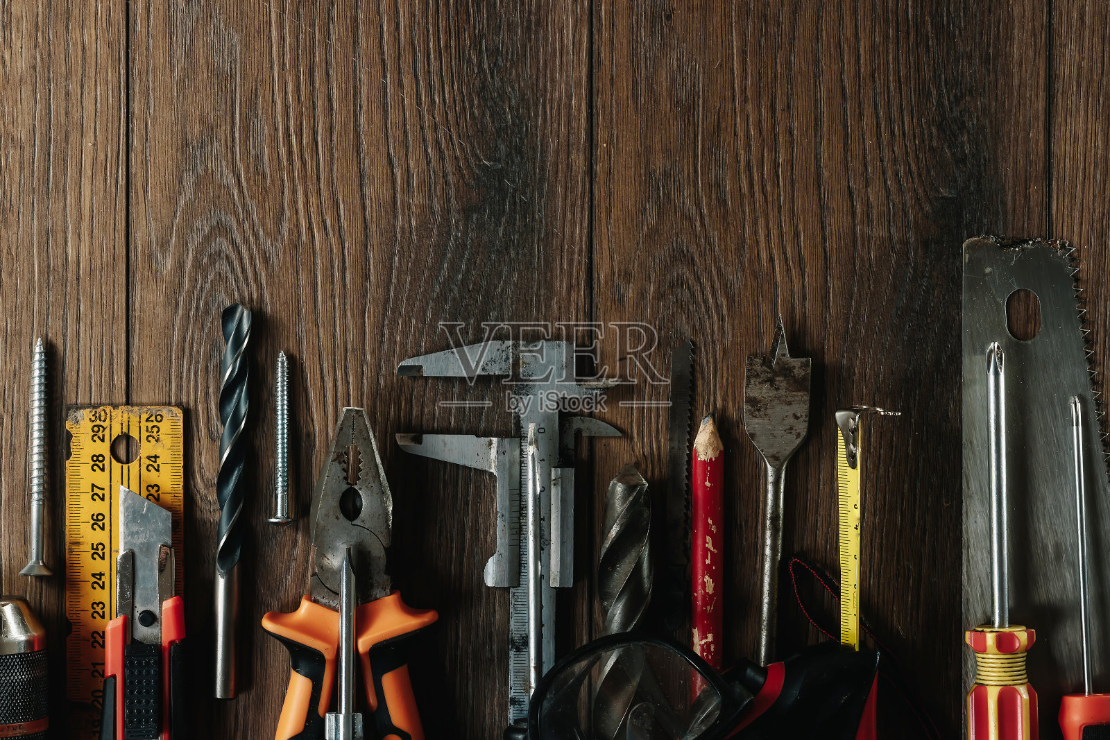 在棕色木制背景上的建筑工具。从以上观点。背景图片,屏幕保护程序。施工、维修、施工、生产、设计的概念。副本的空间。照片摄影图片