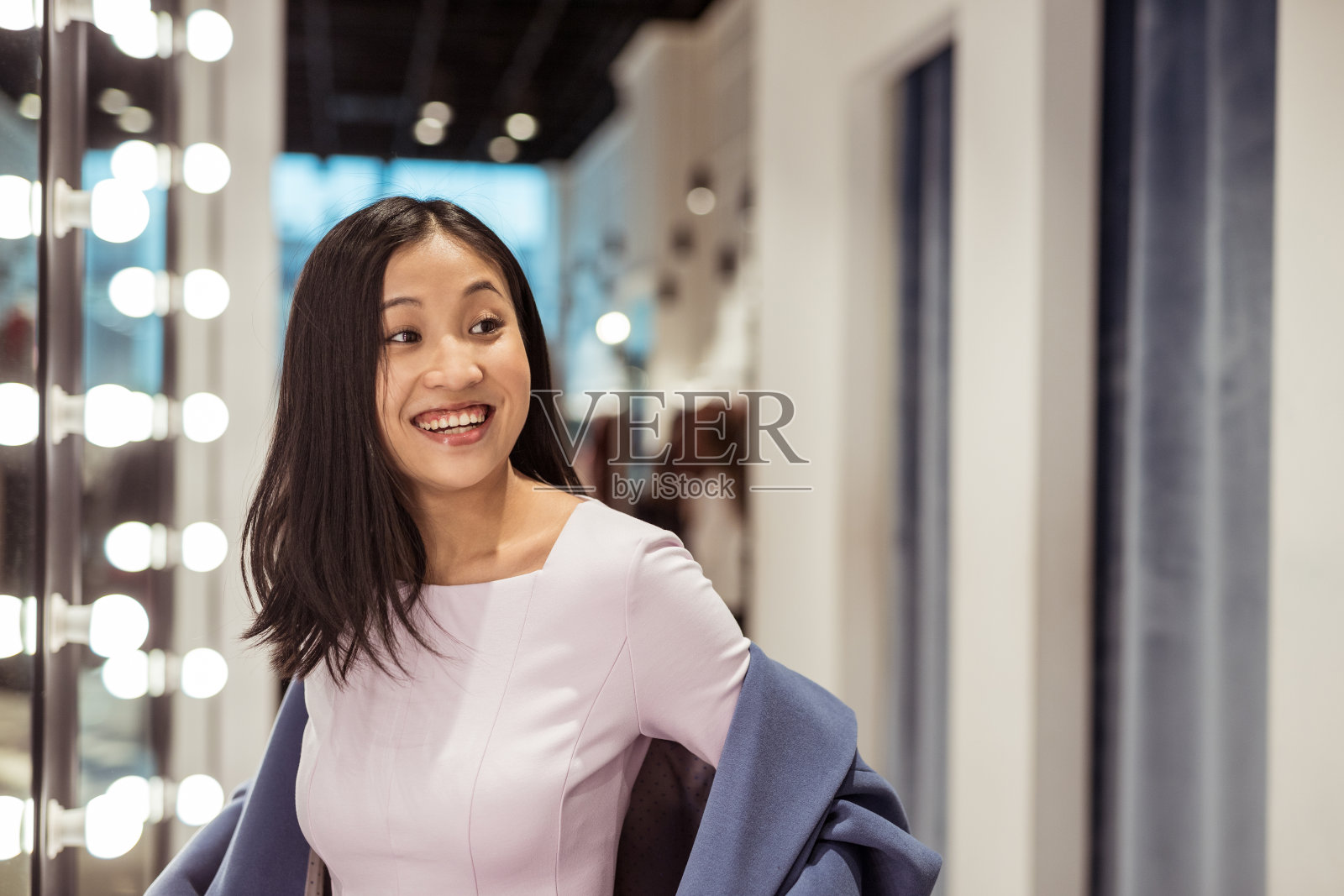 穿着大衣的迷人女孩微笑着照片摄影图片
