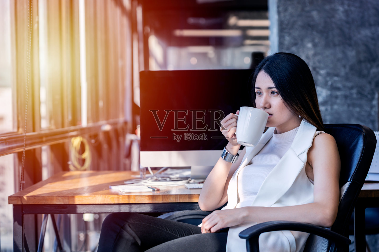 亚洲商业女性正在她的办公桌前放松的咖啡休息照片摄影图片