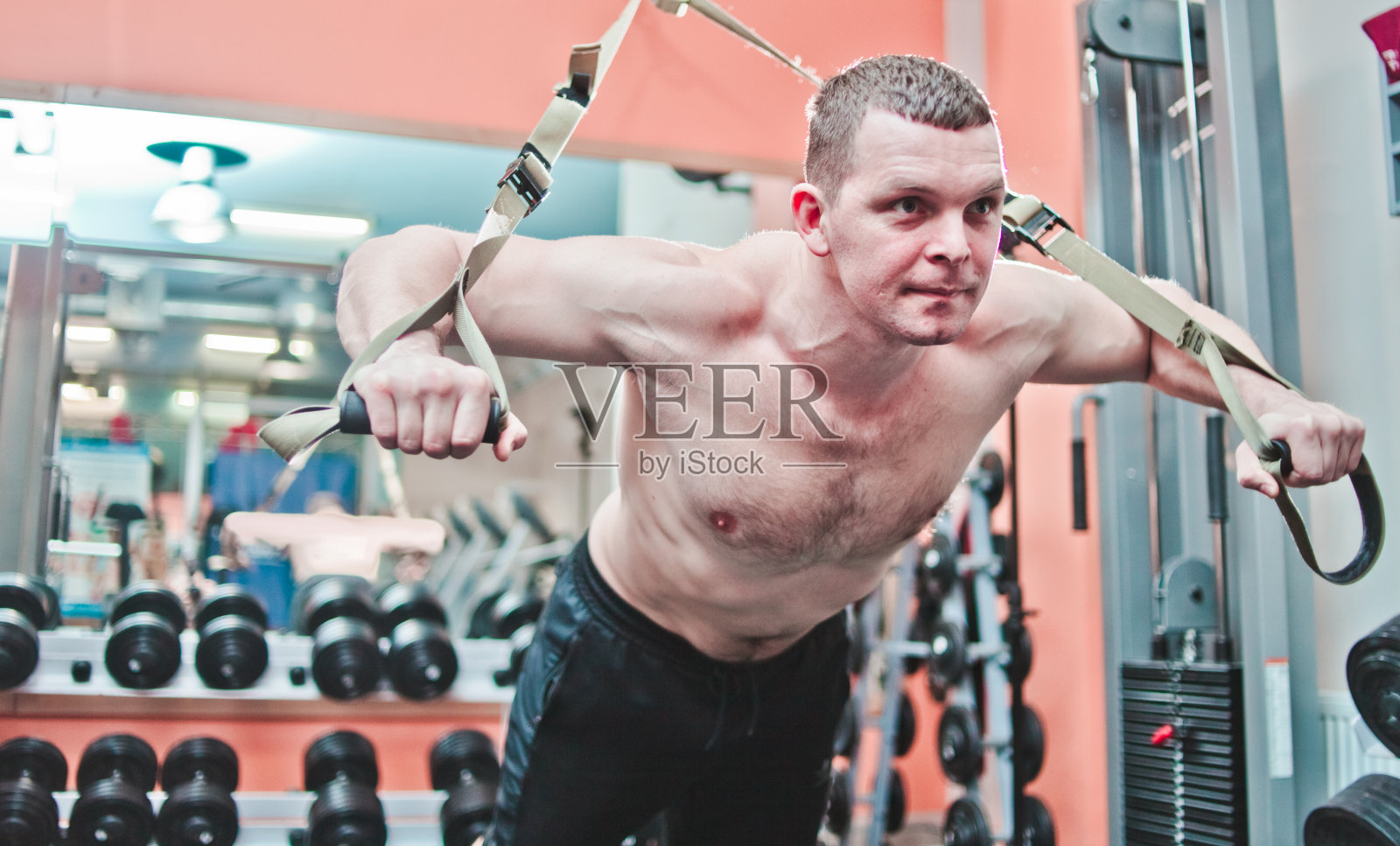 强壮的男人在健身房用健身带做俯卧撑照片摄影图片