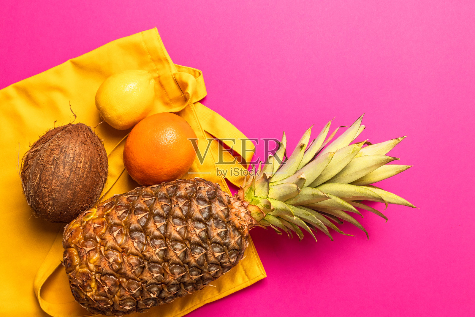 平的。新鲜的异国水果与黄色棉花袋在粉红色的背景。照片摄影图片