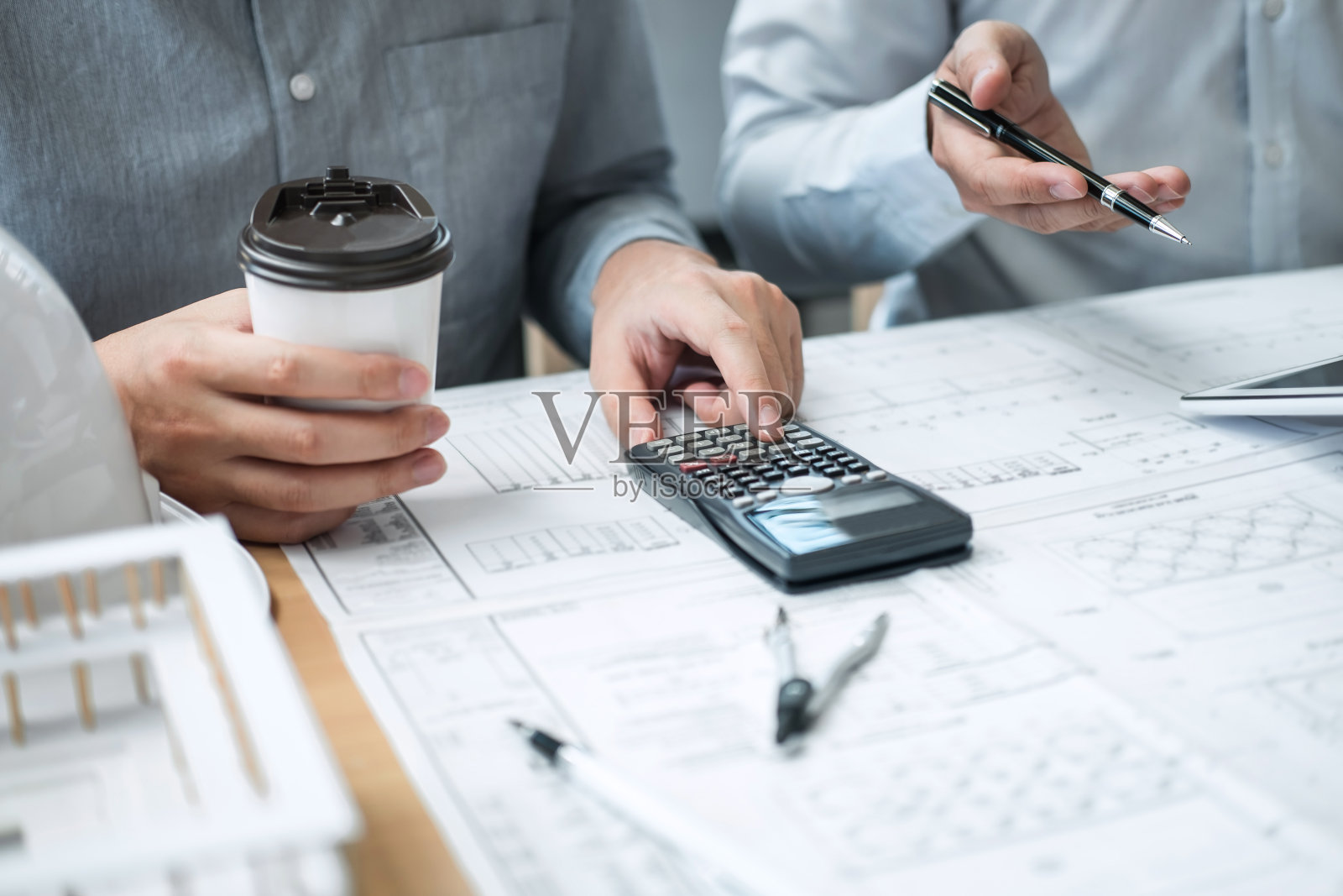 建筑工程或建筑师在工作现场讨论图纸和建筑模型，同时检查建筑项目草图会议的信息照片摄影图片