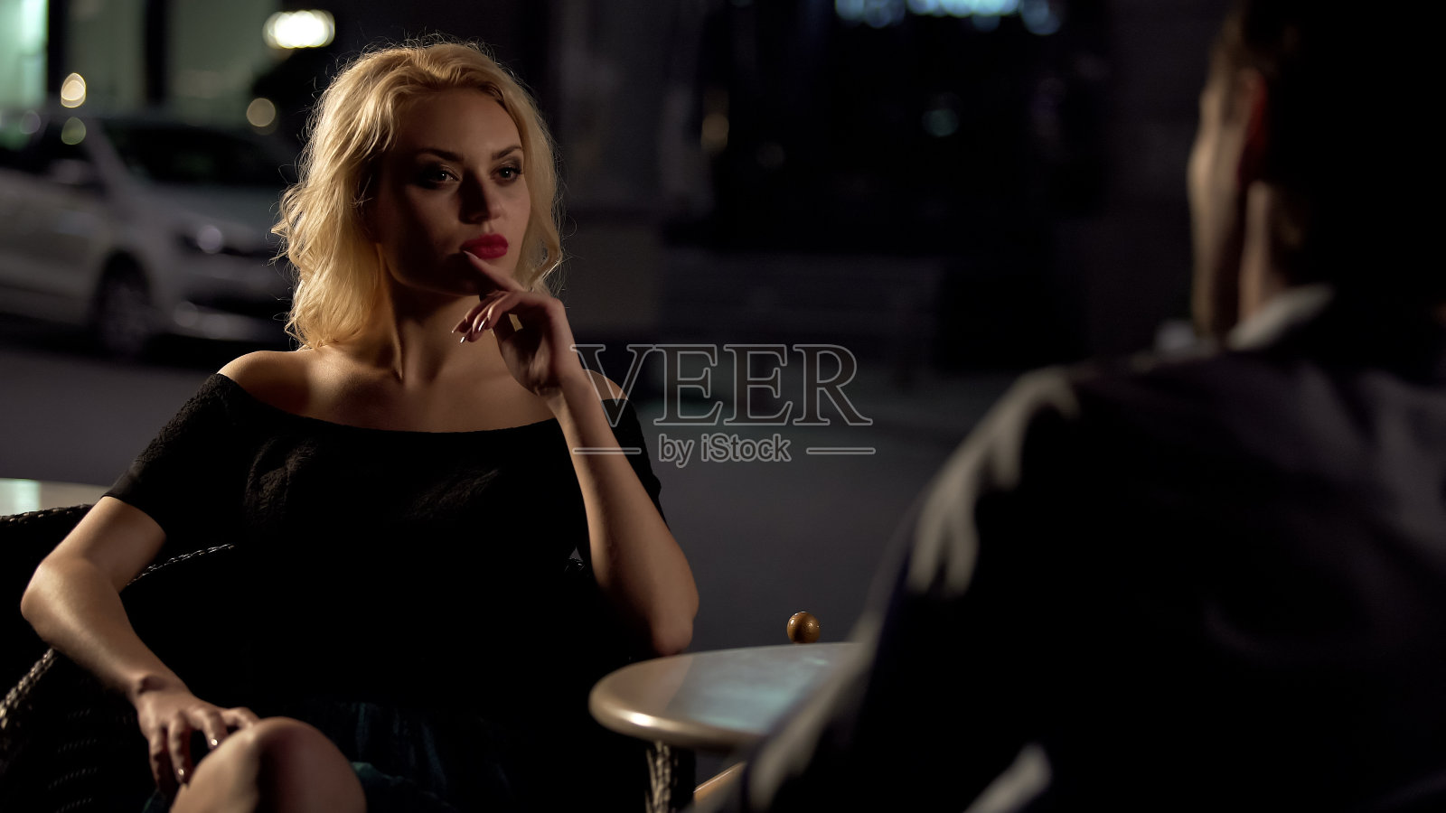 男人与美丽的金发女人在餐厅阳台在晚上调情照片摄影图片