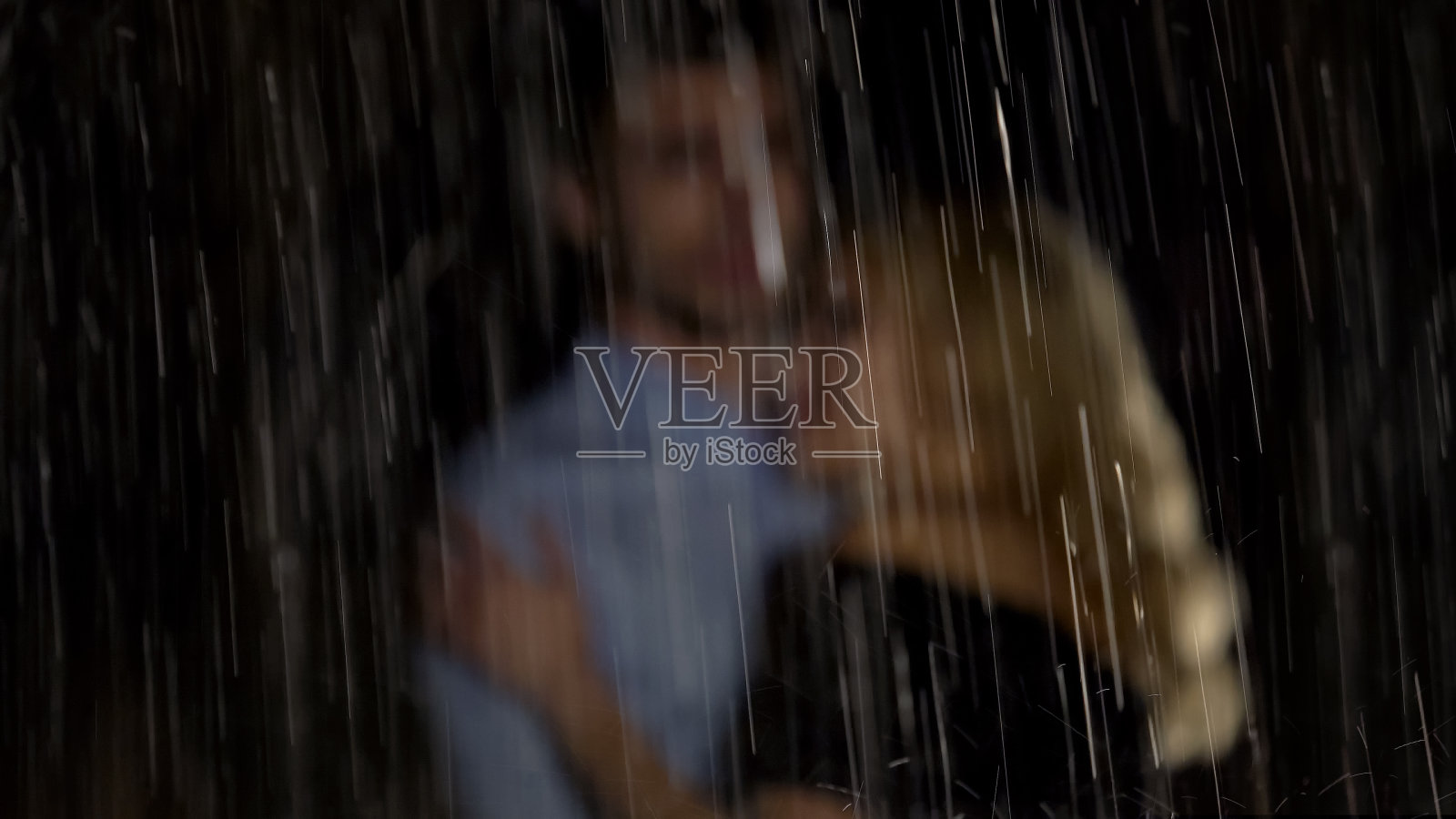 男人和女人在雨中拥抱，等待出租车，浪漫的约会照片摄影图片