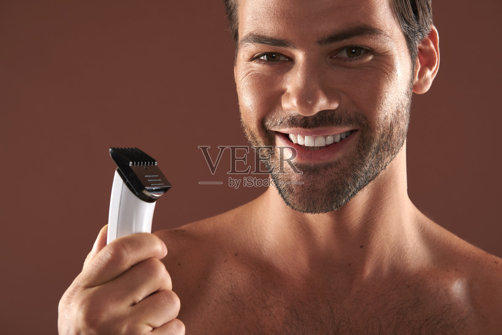 快乐的年轻人手里拿着剃须刀照片摄影图片