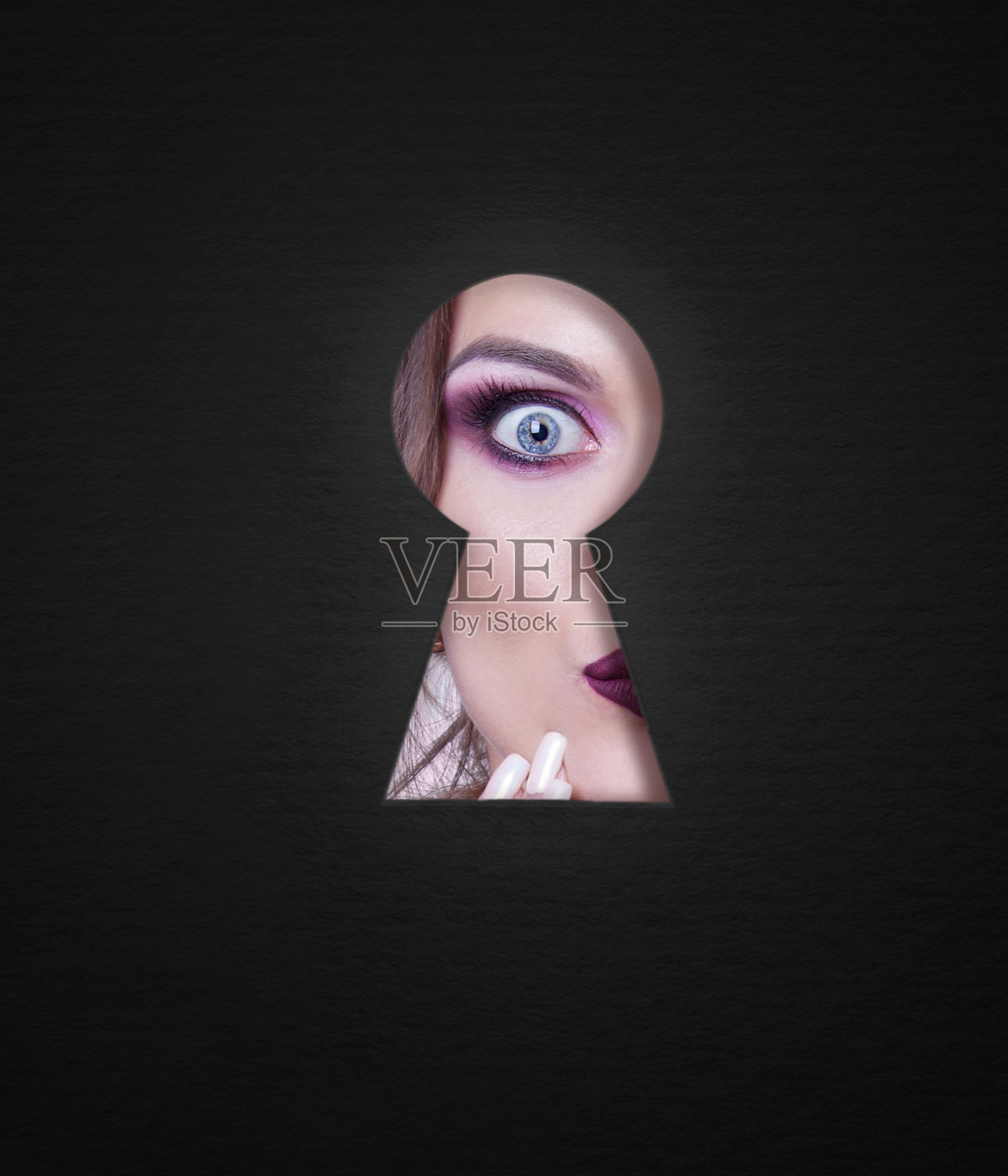 一个透过钥匙孔的女孩，情绪和化妆。照片摄影图片