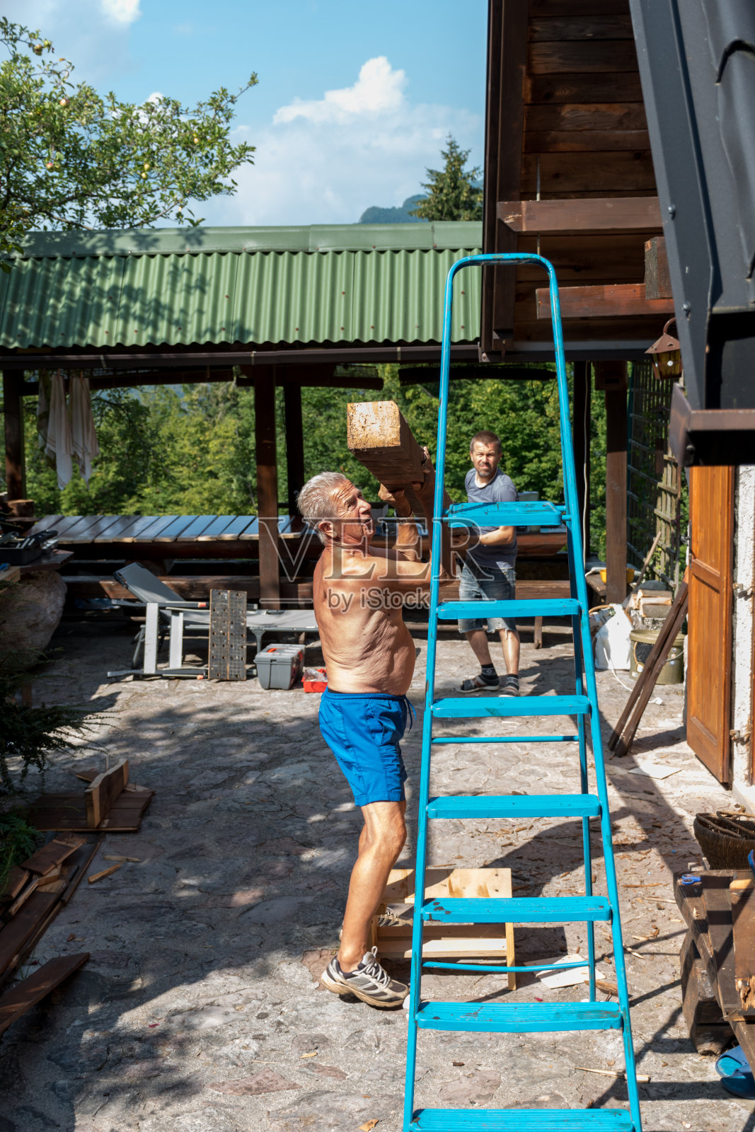 老父子修理和更换阳台上的木甲板照片摄影图片