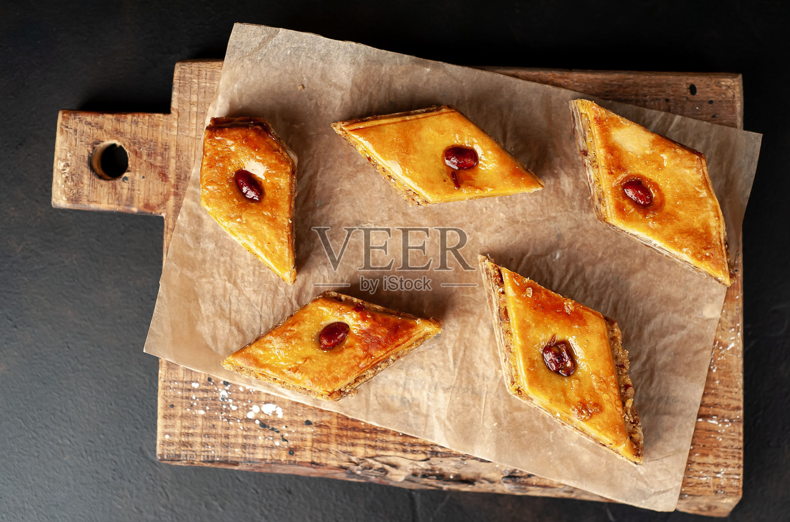 以混凝土为背景的切菜板上的一堆蜂蜜蛋糕照片摄影图片