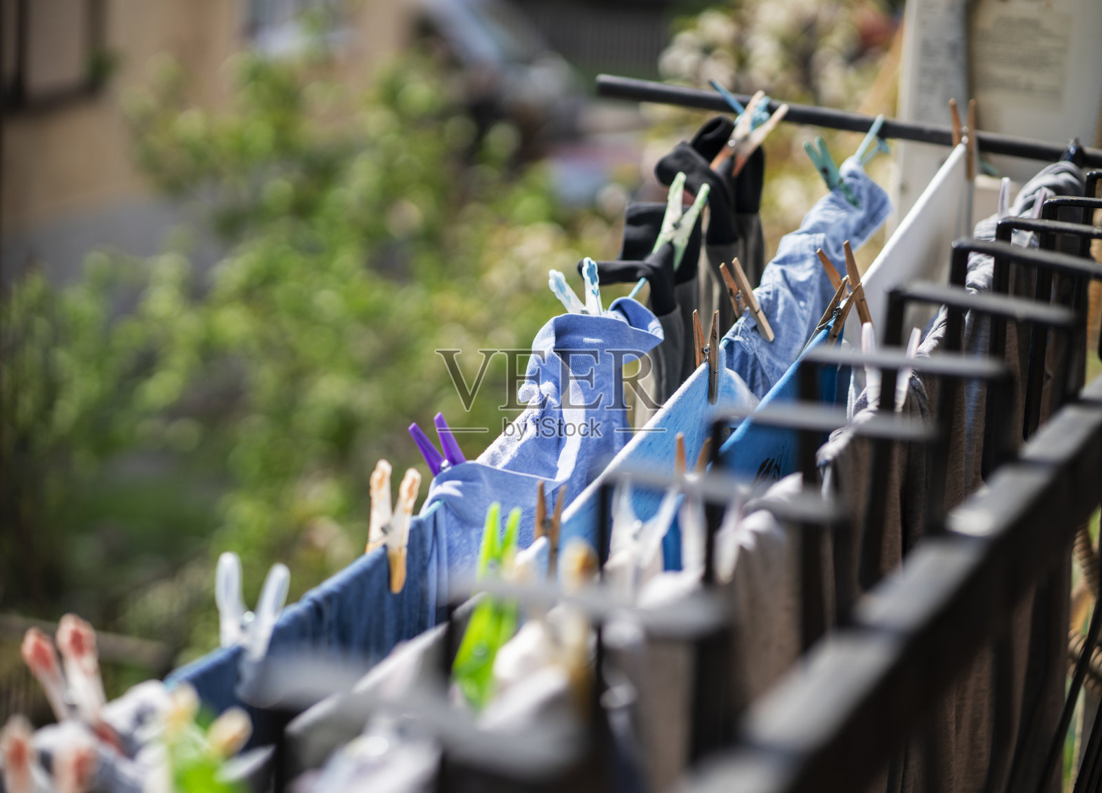 干净的衣服挂在晾衣架上，用衣夹别住照片摄影图片