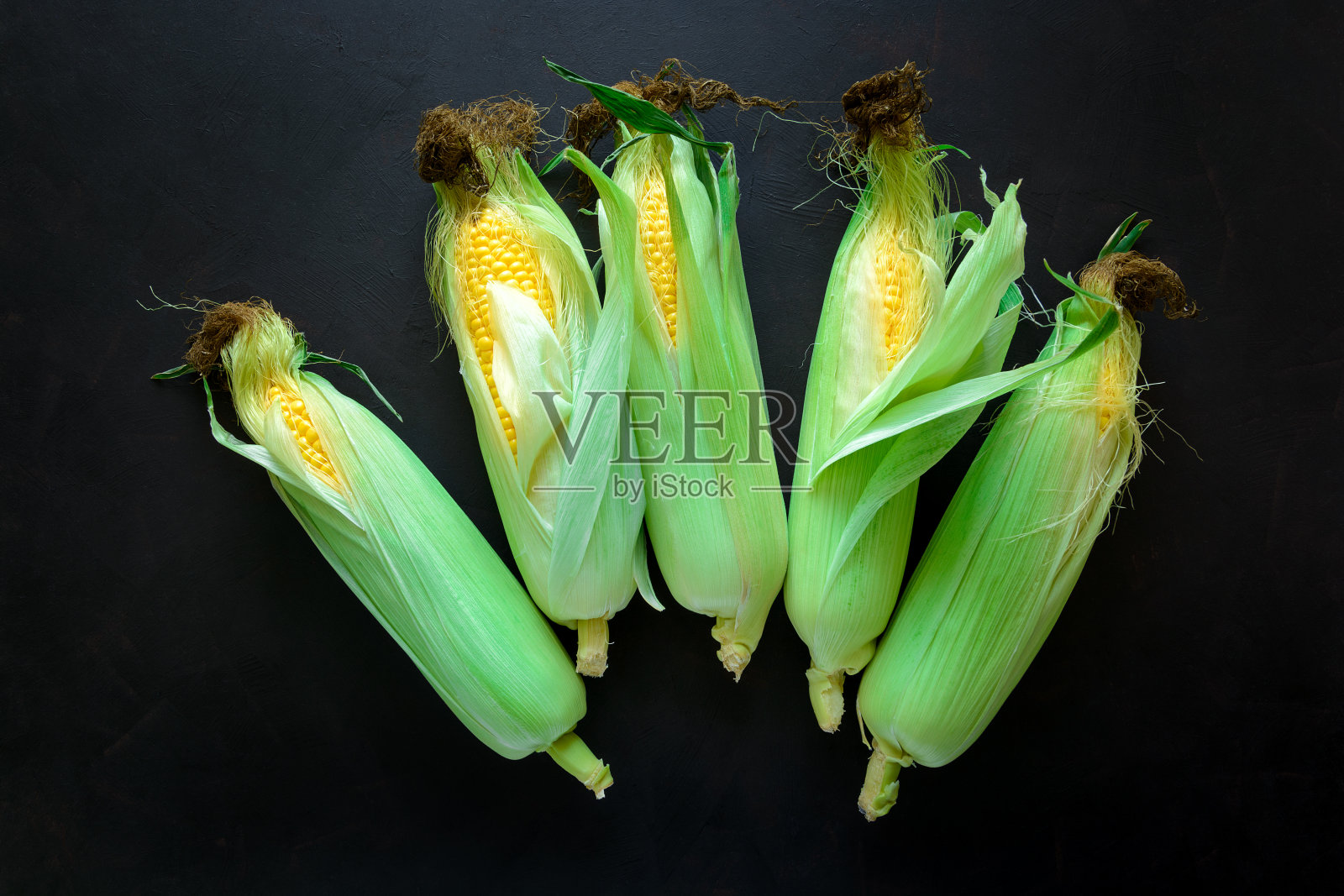 新鲜玉米棒子上棕色的乡村木制背景前视图健康饮食或素食的概念照片