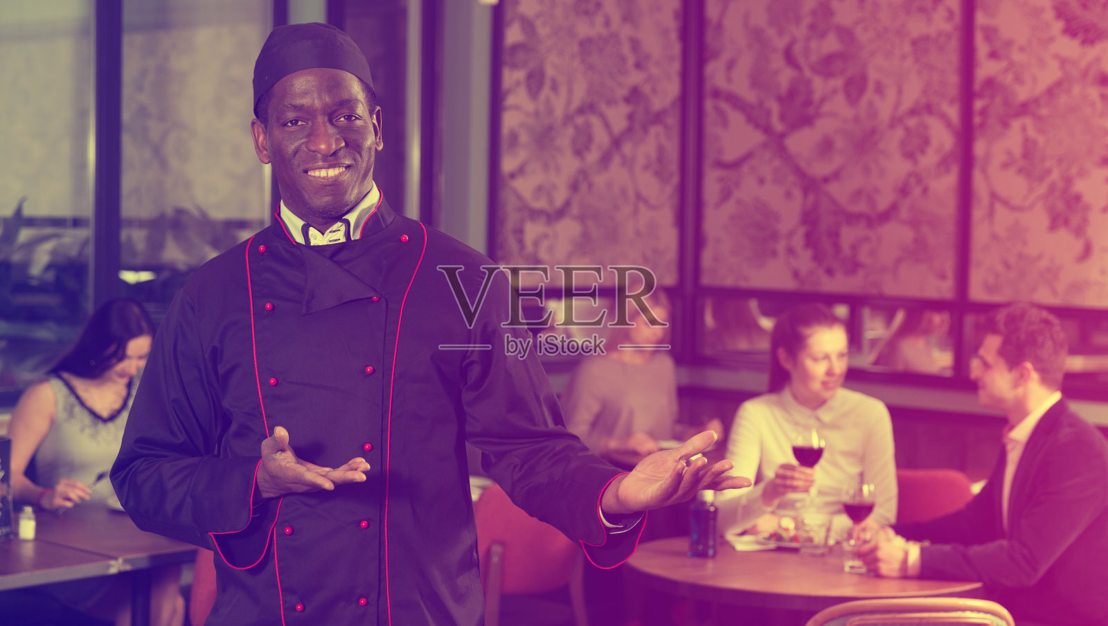 微笑的非洲裔美国厨师邀请到餐厅照片摄影图片