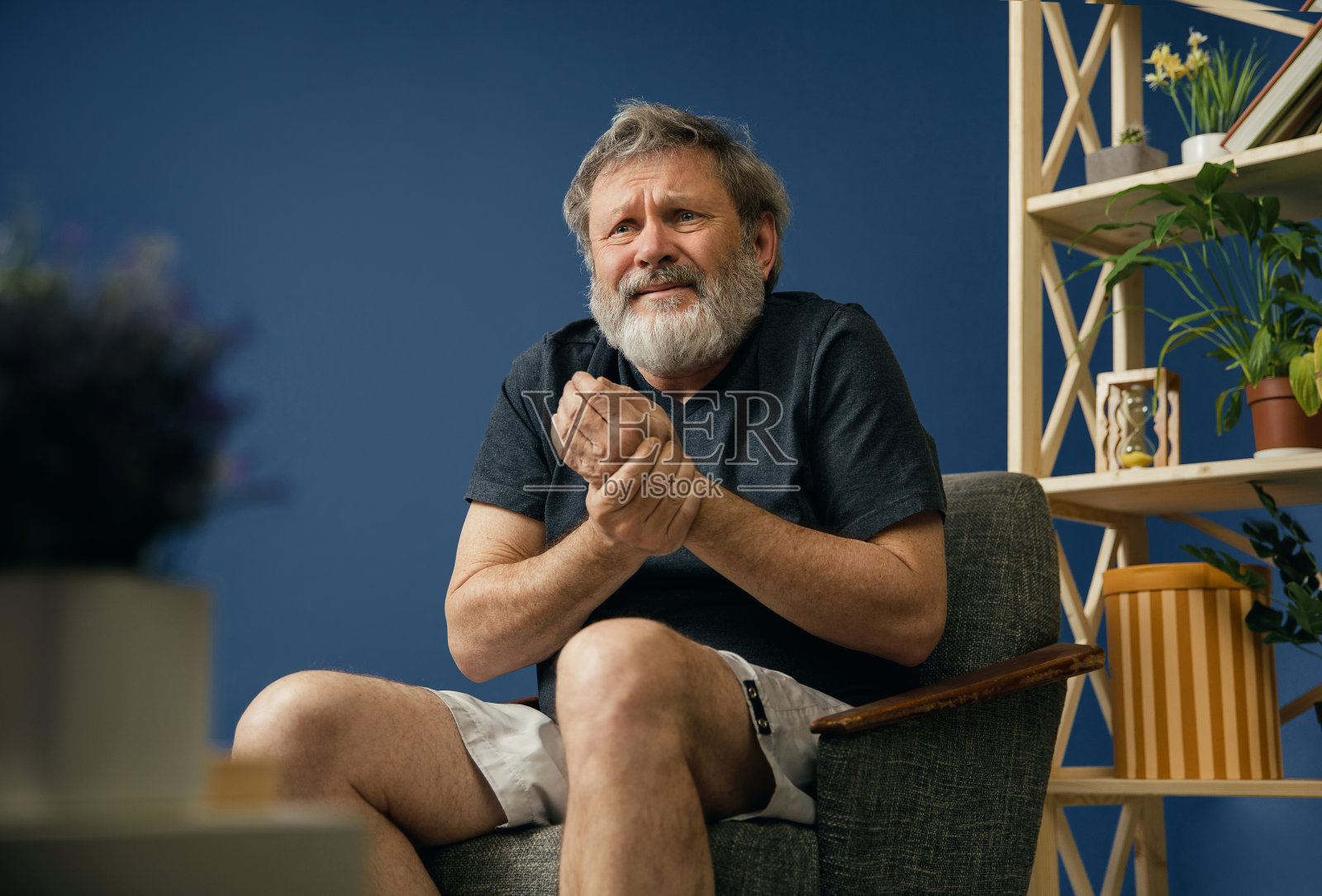 饱受病痛折磨的胡子老人照片摄影图片