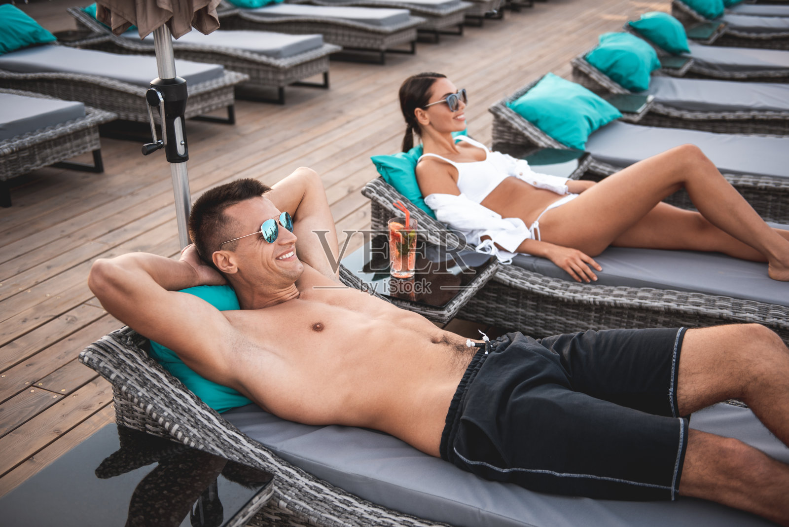 男人和女人在躺椅上休息，愉快地微笑着照片摄影图片