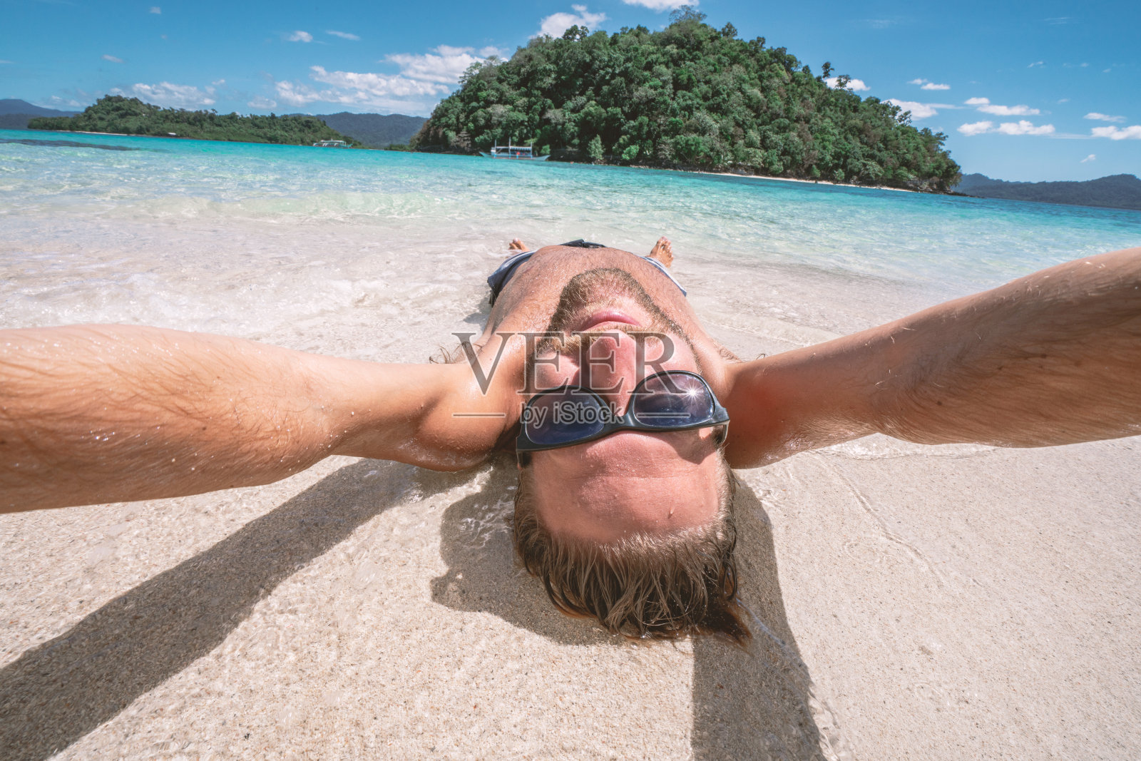酷酷的年轻人在热带海滩上自拍颠倒享受假期照片摄影图片