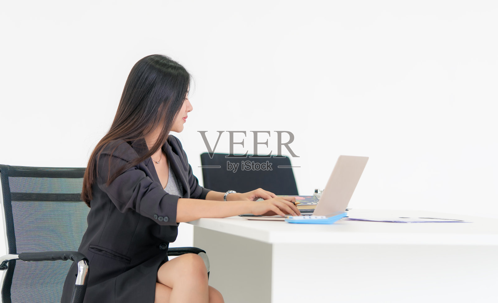 年轻女子使用笔记本电脑在办公室隔离白色照片摄影图片