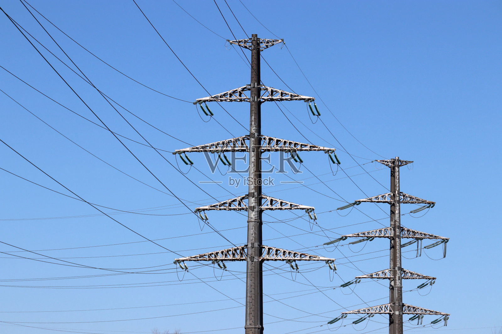 高压电线支持与电线隔离在明确的蓝天背景照片摄影图片