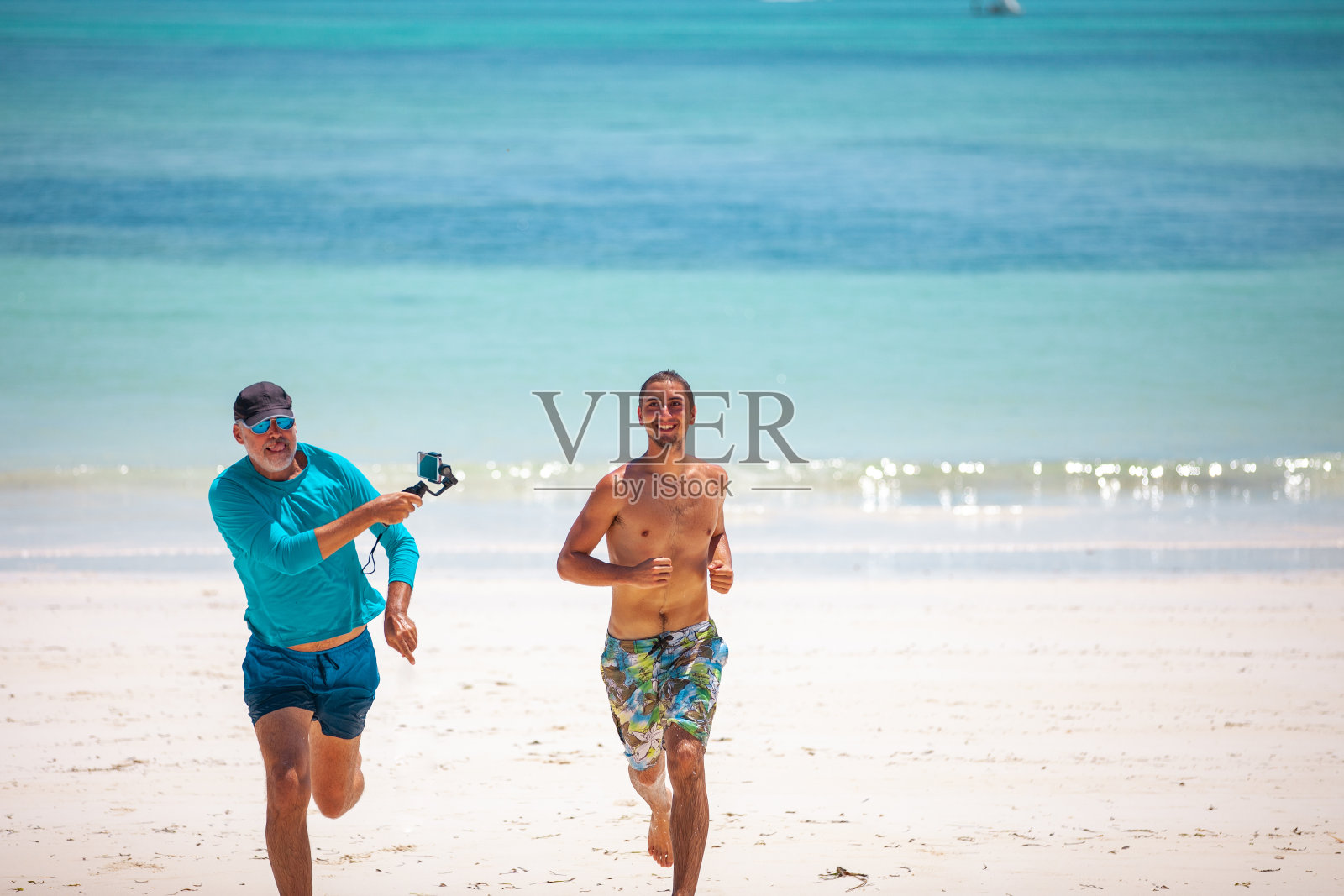 成熟的男人在沙滩上拍摄年轻的成年人照片摄影图片