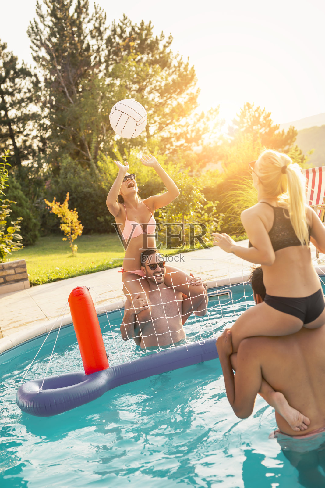 朋友们在游泳池聚会上打排球照片摄影图片