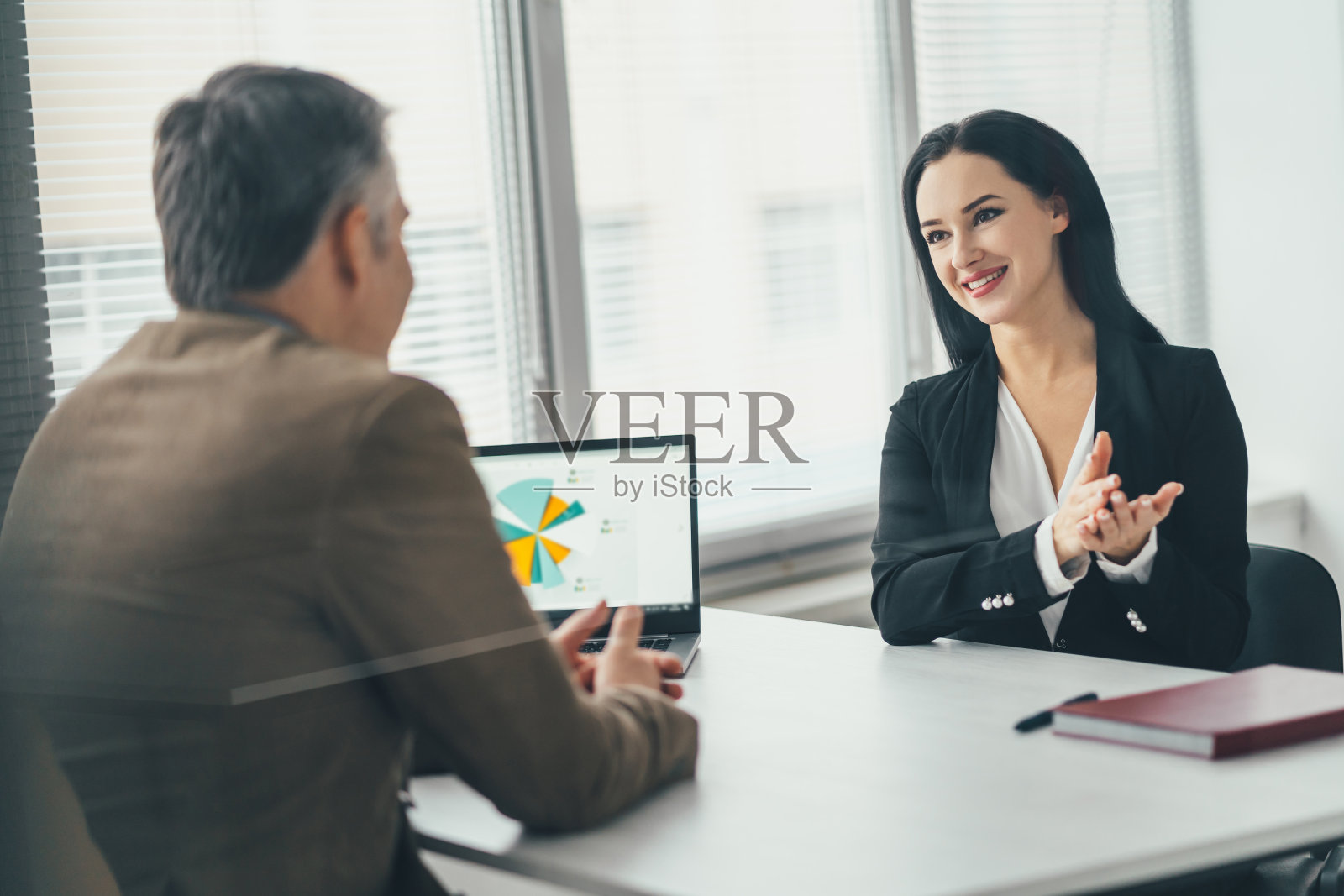 女商人和男商人在办公室的桌子上聊天照片摄影图片
