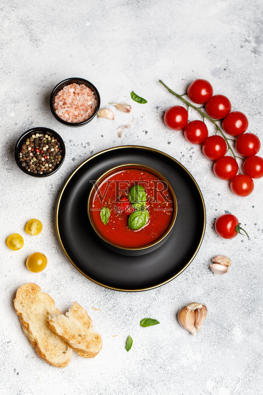 传统的西班牙冷番茄汤在一个碗在石头的背景。传统的西班牙食物。用成熟的西红柿做成的西班牙冷汤的概念。复制空间,特写照片摄影图片