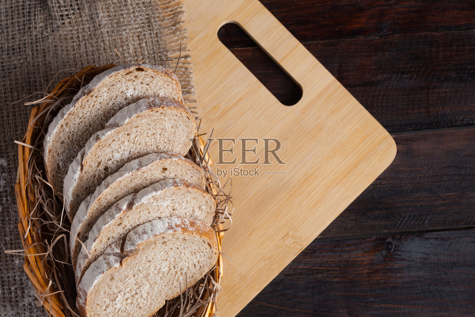 新鲜切成薄片的柳条碗放在橡木板上，上面撒有面粉，背景是亚麻织物。照片俯视图照片摄影图片