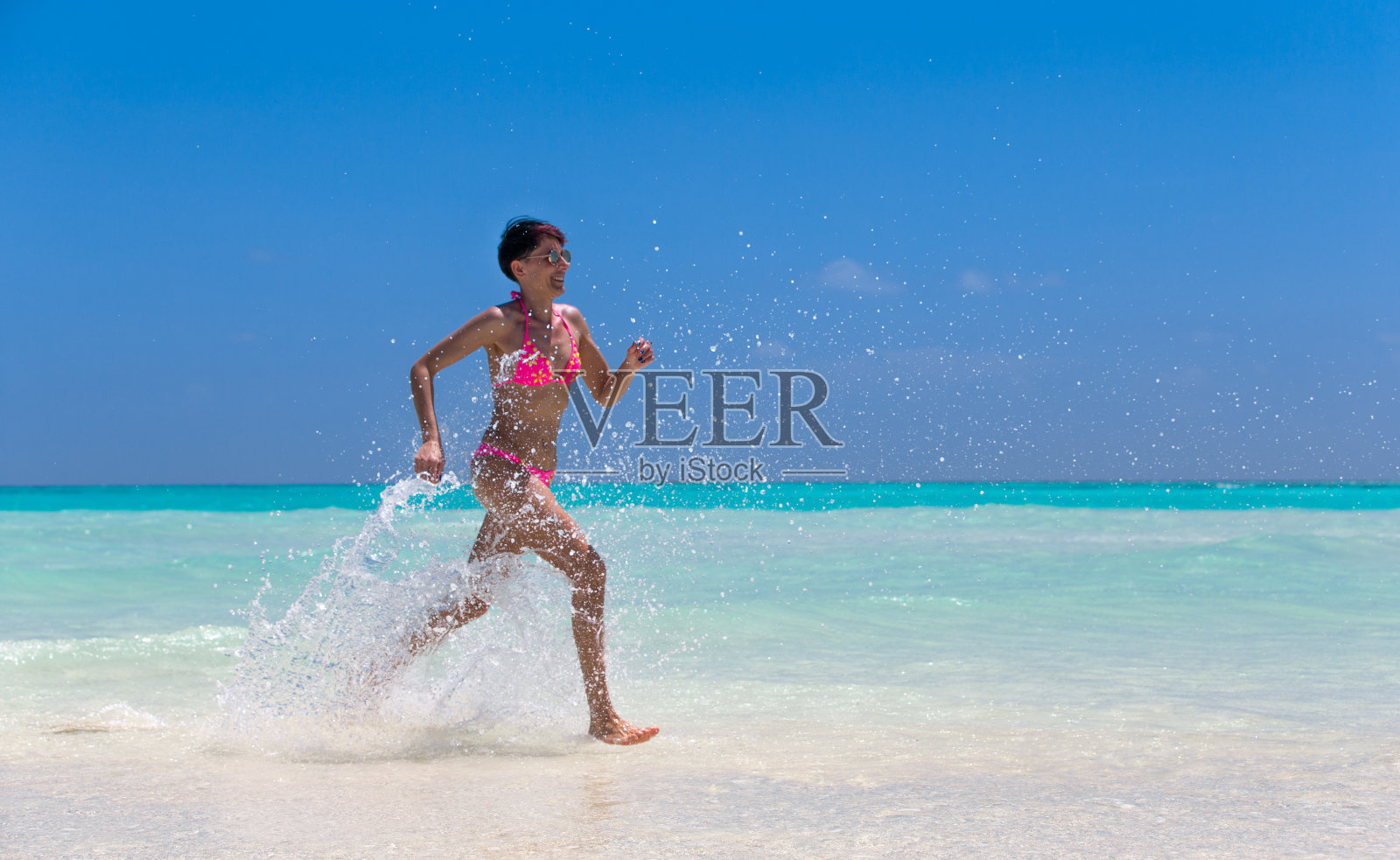 成年女子在田园诗般的海岸线上奔跑照片摄影图片