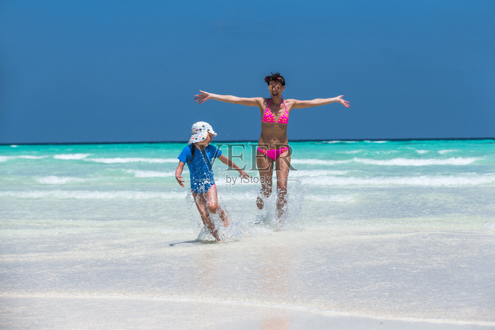 妈妈和女儿在海里奔跑和玩耍照片摄影图片