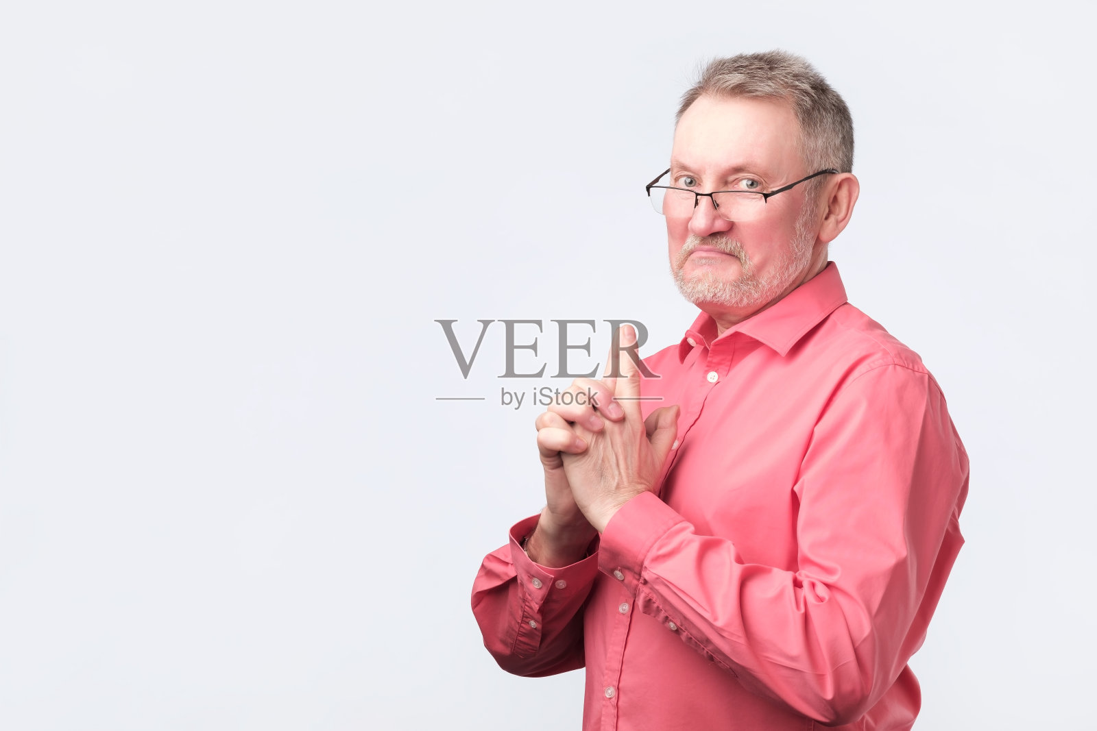 身穿红衬衫的老人，摆着枪的姿势。照片摄影图片