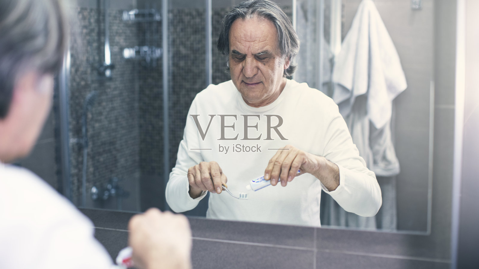 老人在镜子前刷牙照片摄影图片