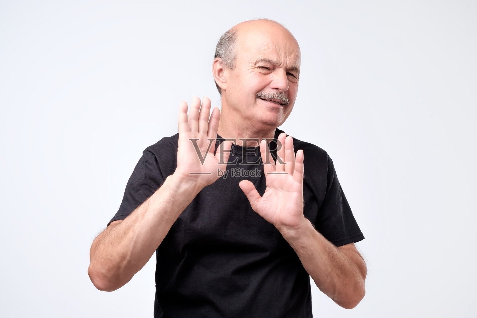 有魅力的成熟秃顶男人表现出拒绝的姿态。照片摄影图片