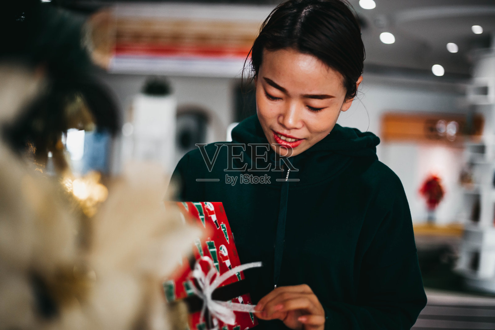 年轻女子拿着圣诞或新年礼物盒和圣诞树照片摄影图片