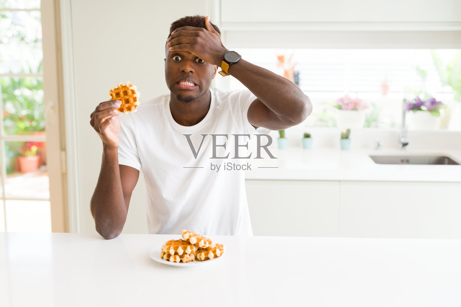 非裔美国人吃甜的比利时华夫饼强调用手顶在头上，震惊的羞愧和惊讶的脸，愤怒和沮丧。为错误而恐惧和不安。照片摄影图片