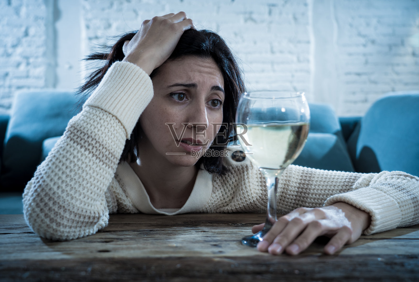 独自在家喝葡萄酒的、有压力的、绝望的年轻女人。感到沮丧、失落和虚弱，试图通过饮酒感觉好些。不健康行为、抑郁症和酗酒概念。照片摄影图片