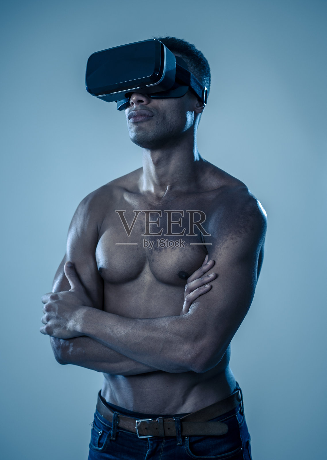 有吸引力的强壮肌肉的非洲男子使用增强VR眼镜，对模拟探索新体验感到兴奋。在虚拟现实，虚拟健身和新技术概念。照片摄影图片