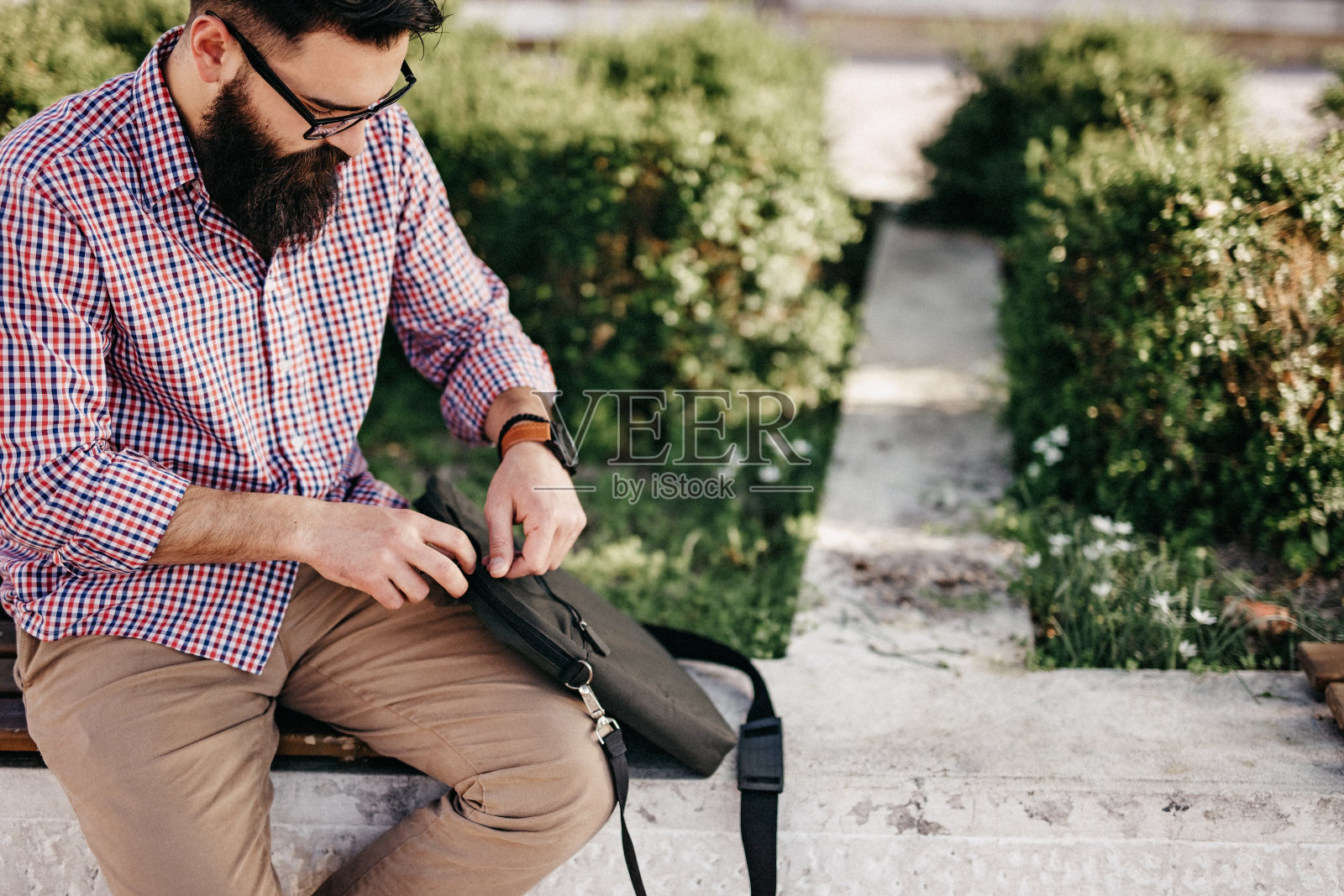 有魅力的大胡子男子坐在公园长椅上照片摄影图片