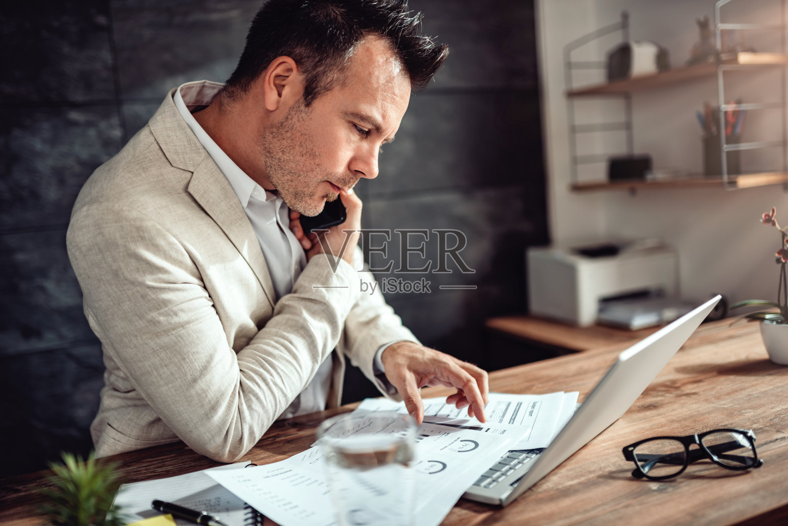 用智能手机聊天，在办公室里做文书工作照片摄影图片