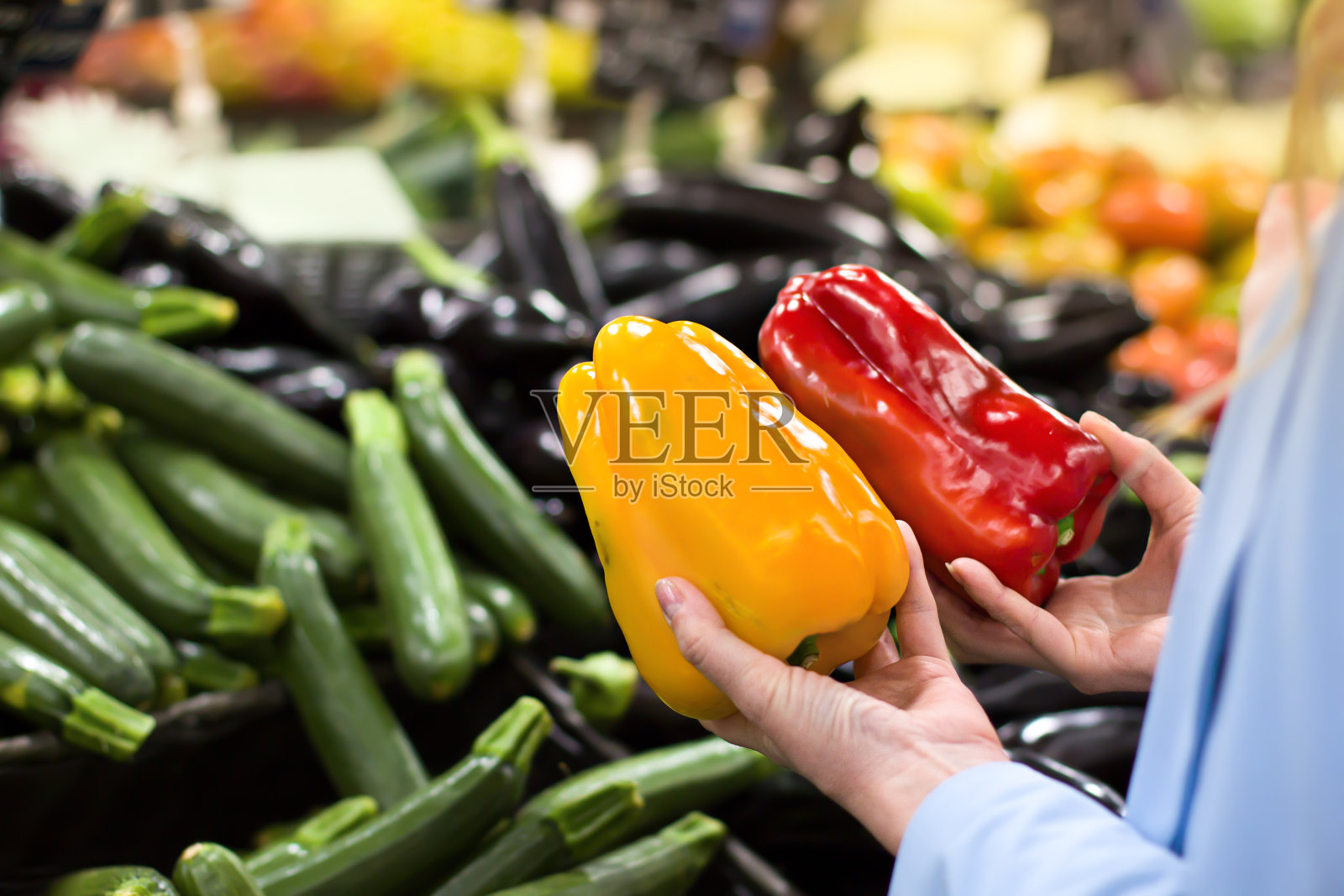 在超市里，妇女们用手挑选辣椒照片摄影图片