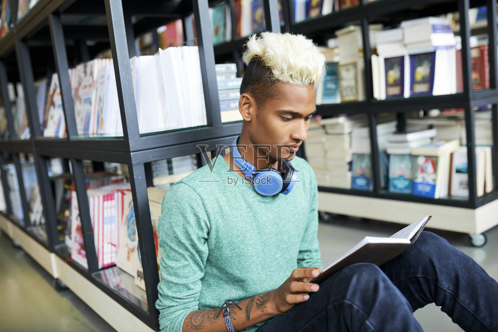 好奇的学生在图书馆里阅读课本照片摄影图片