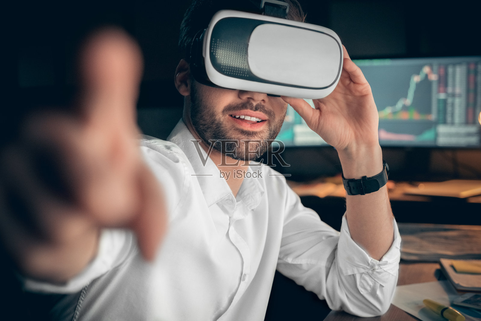 商人戴着虚拟眼镜在办公室与虚拟接口工作照片摄影图片