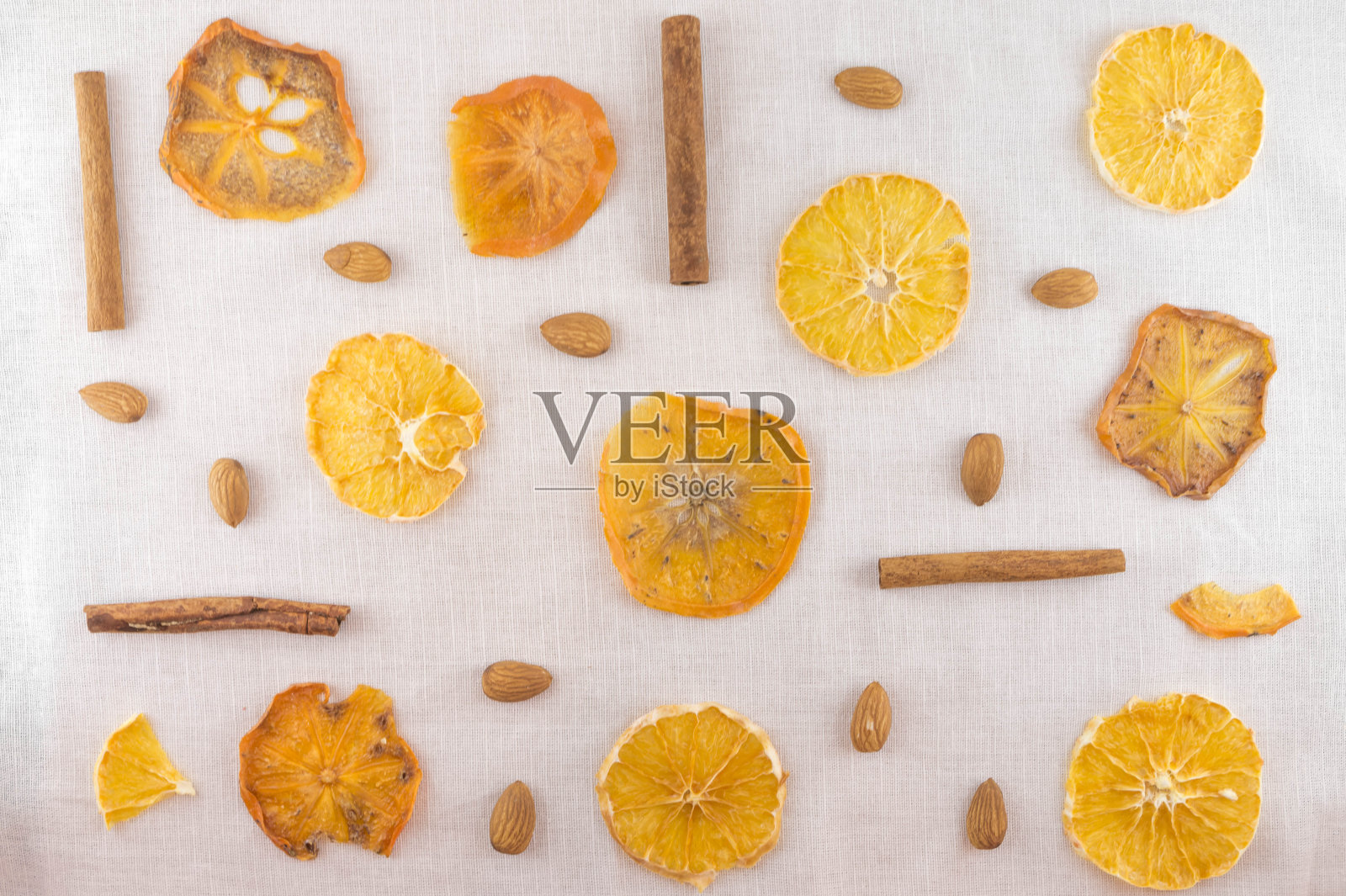 舒适的白色背景。橙干、柿子和杏仁片。平的。照片摄影图片
